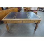 A Victorian oak and black leather topped double sided four drawer library table