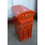 A painted red metal Post Office letter box, with key