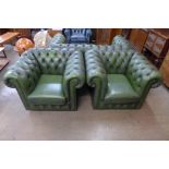 A pair of green leather club armchairs