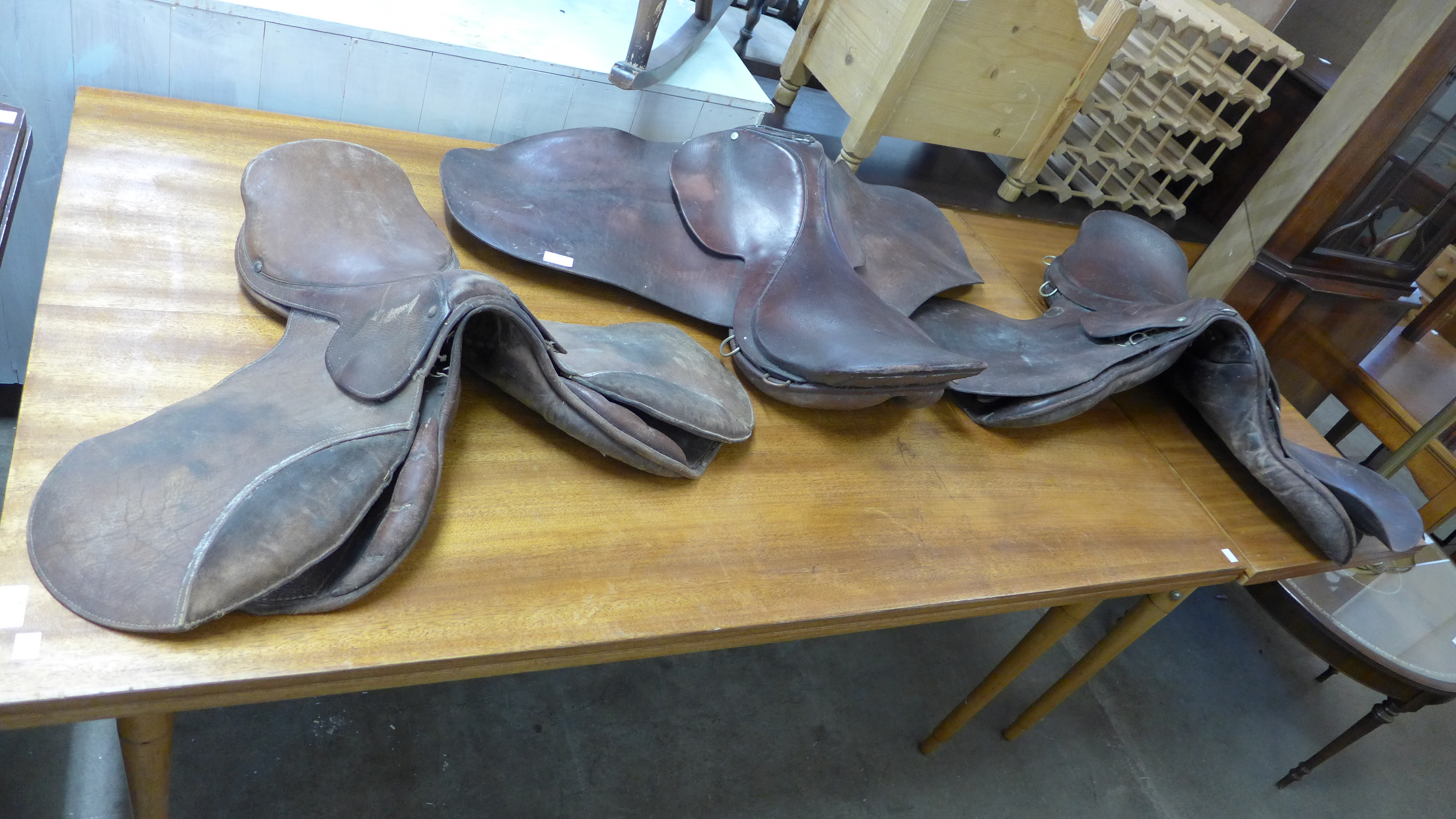 Three leather horse saddles