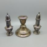 A silver salt and pepper pair, 85g, and a silver candlestick