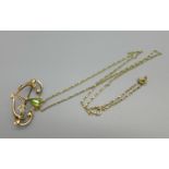 A 9ct gold Art Nouveau style pendant/brooch set with seed pearls and peridot on a 9ct gold chain,