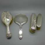 Three silver backed brushes and hand mirror