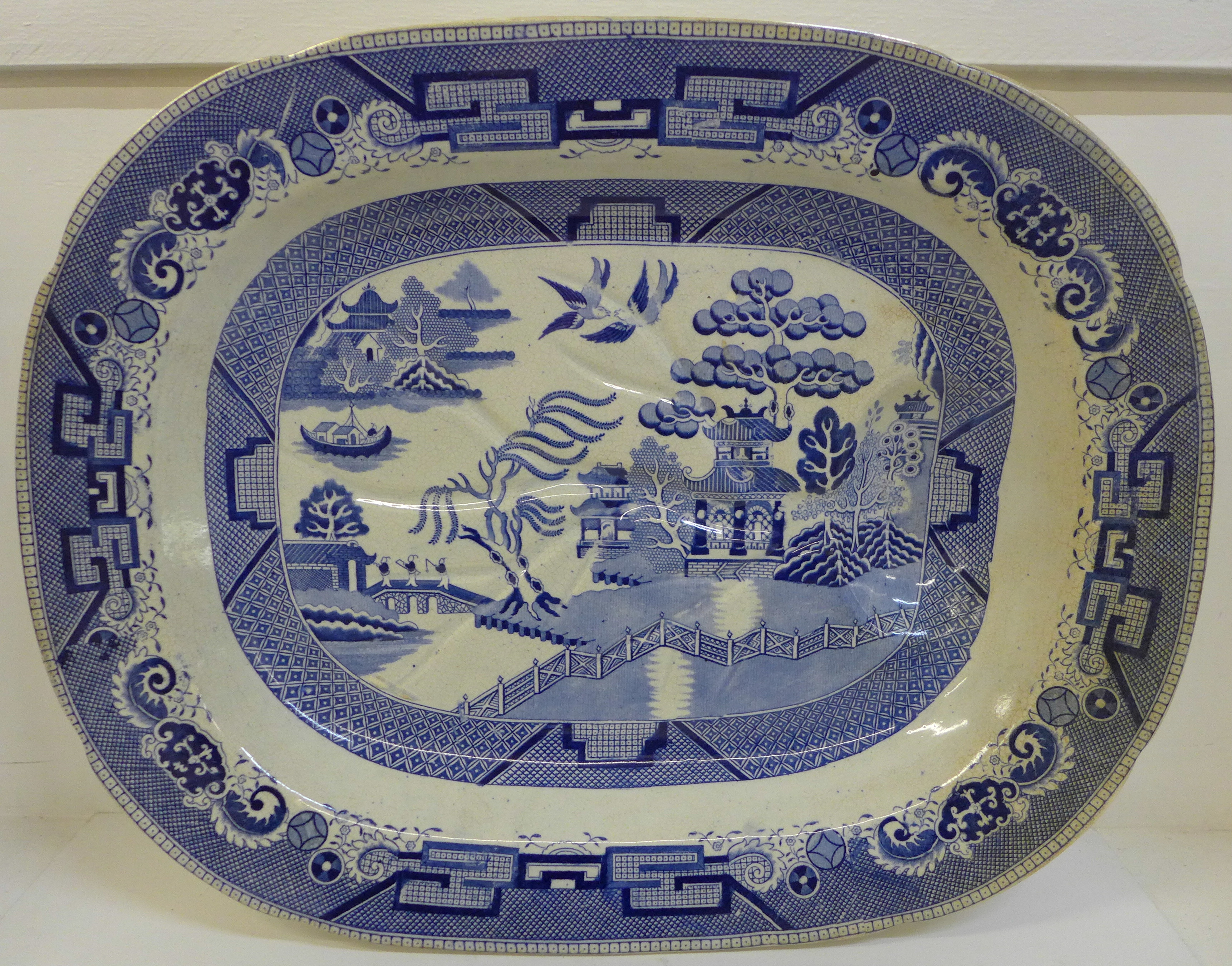 A large blue and white Willow pattern meat plate