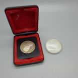 Two coins; British Columbia commemorative silver dollar and a Montreal 1976 Olympics 5 Dollars coin