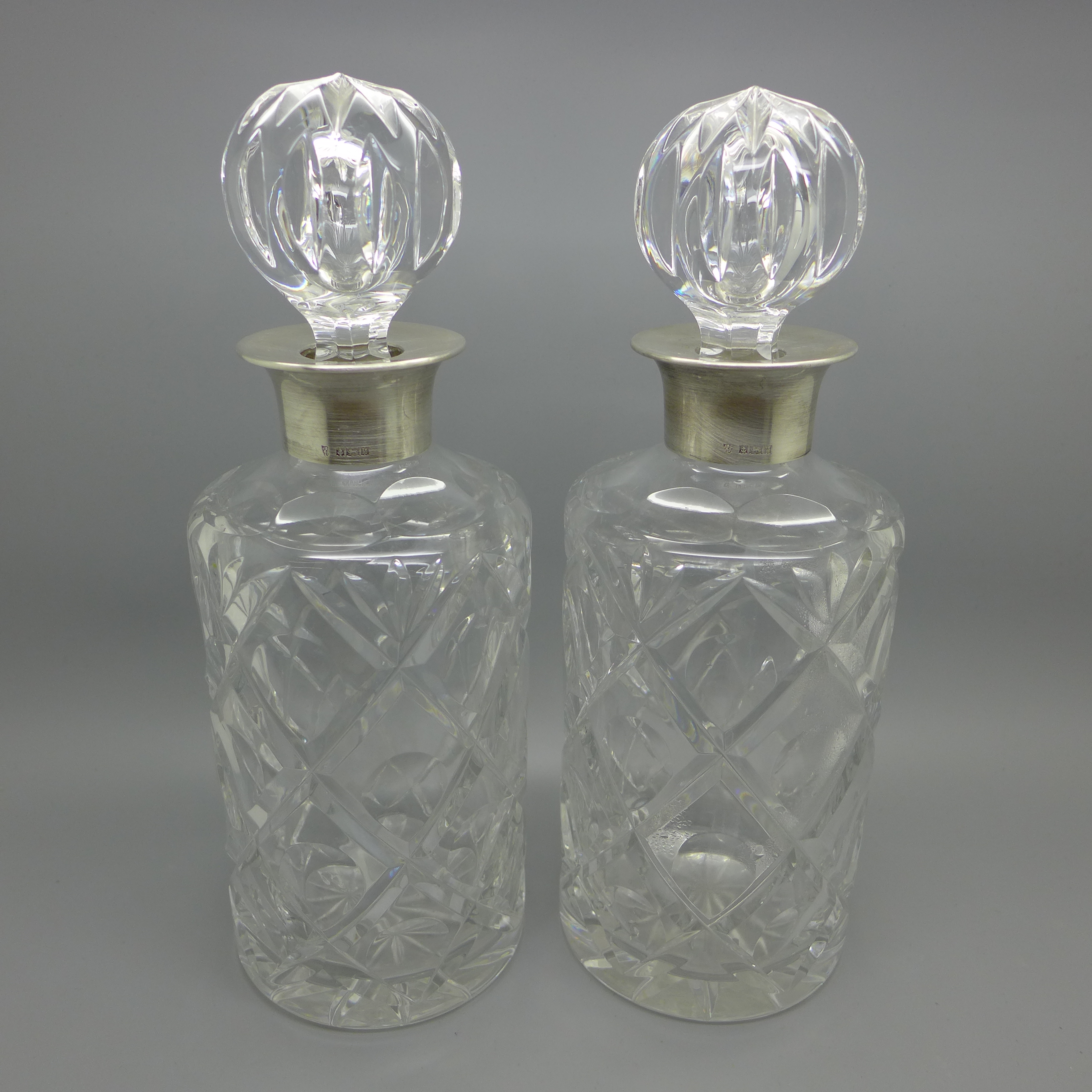 A pair of silver mounted crystal glass decanters