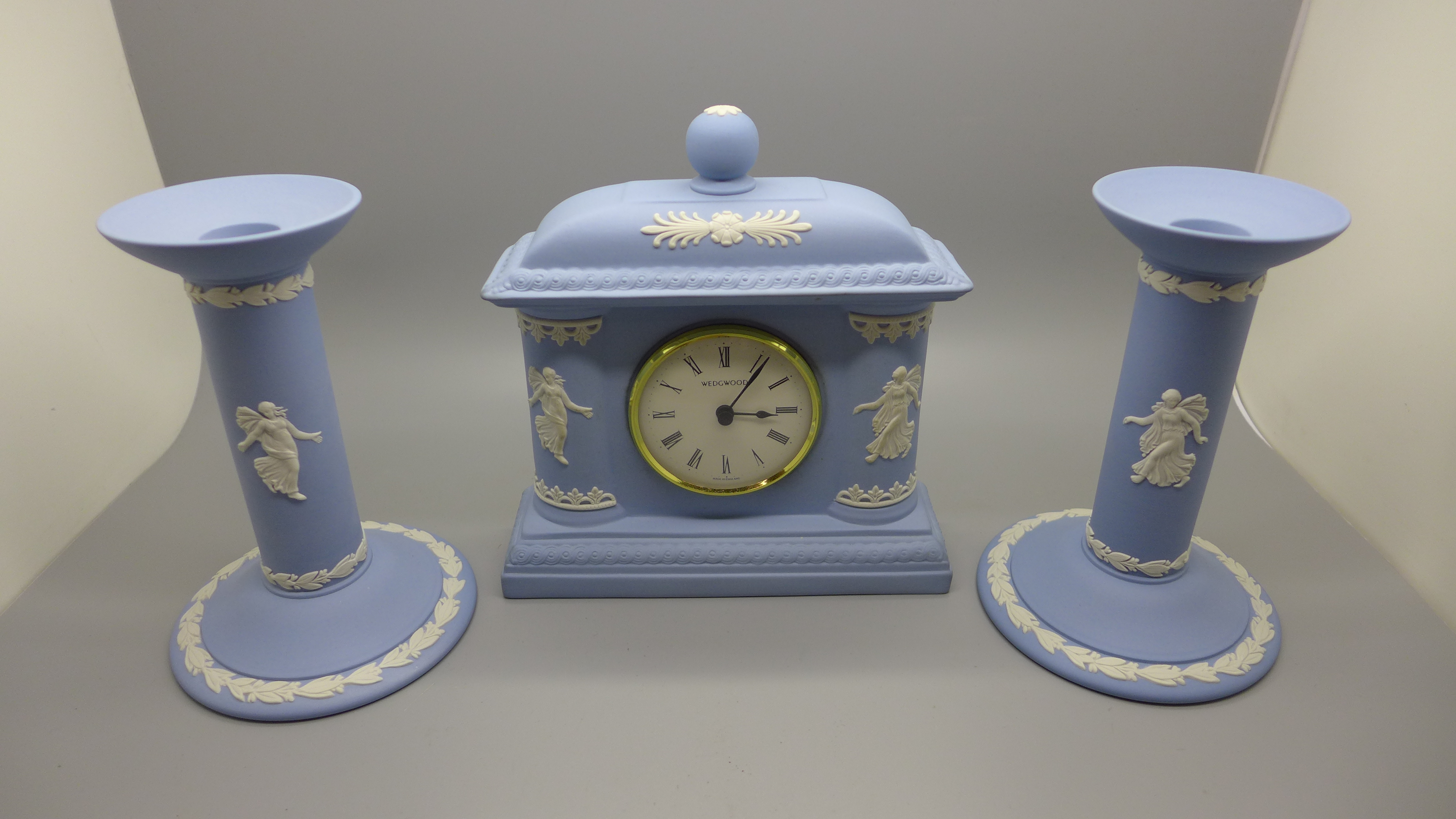 A Wedgwood Jasperware The Dancing Hours clock and a pair of candlesticks