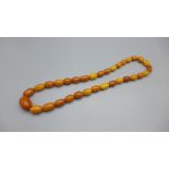 A string of amber coloured beads, some beads a/f