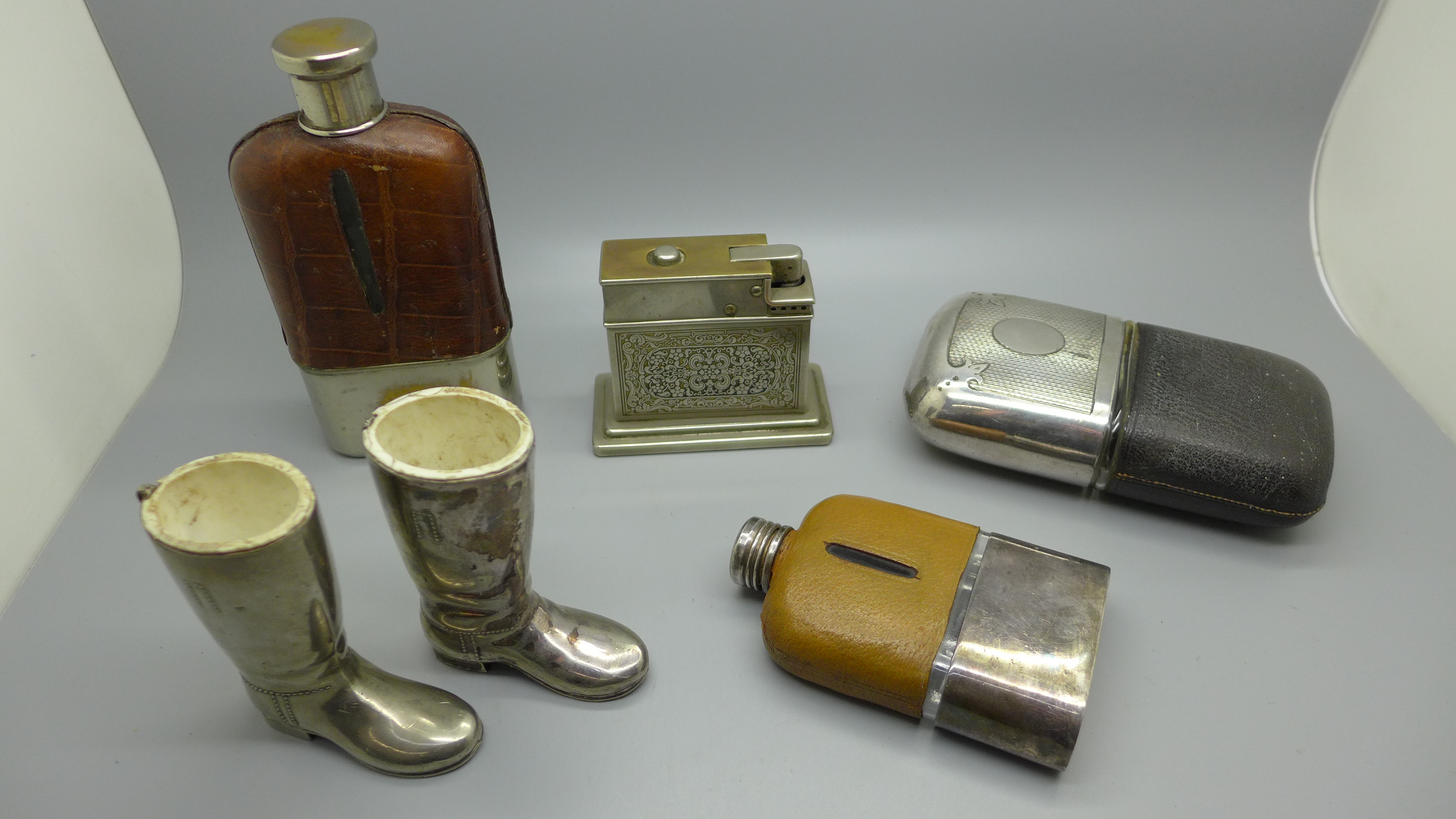 Three hip flasks, with silver plated cups, two Wellington boot match holders and a Myflam table