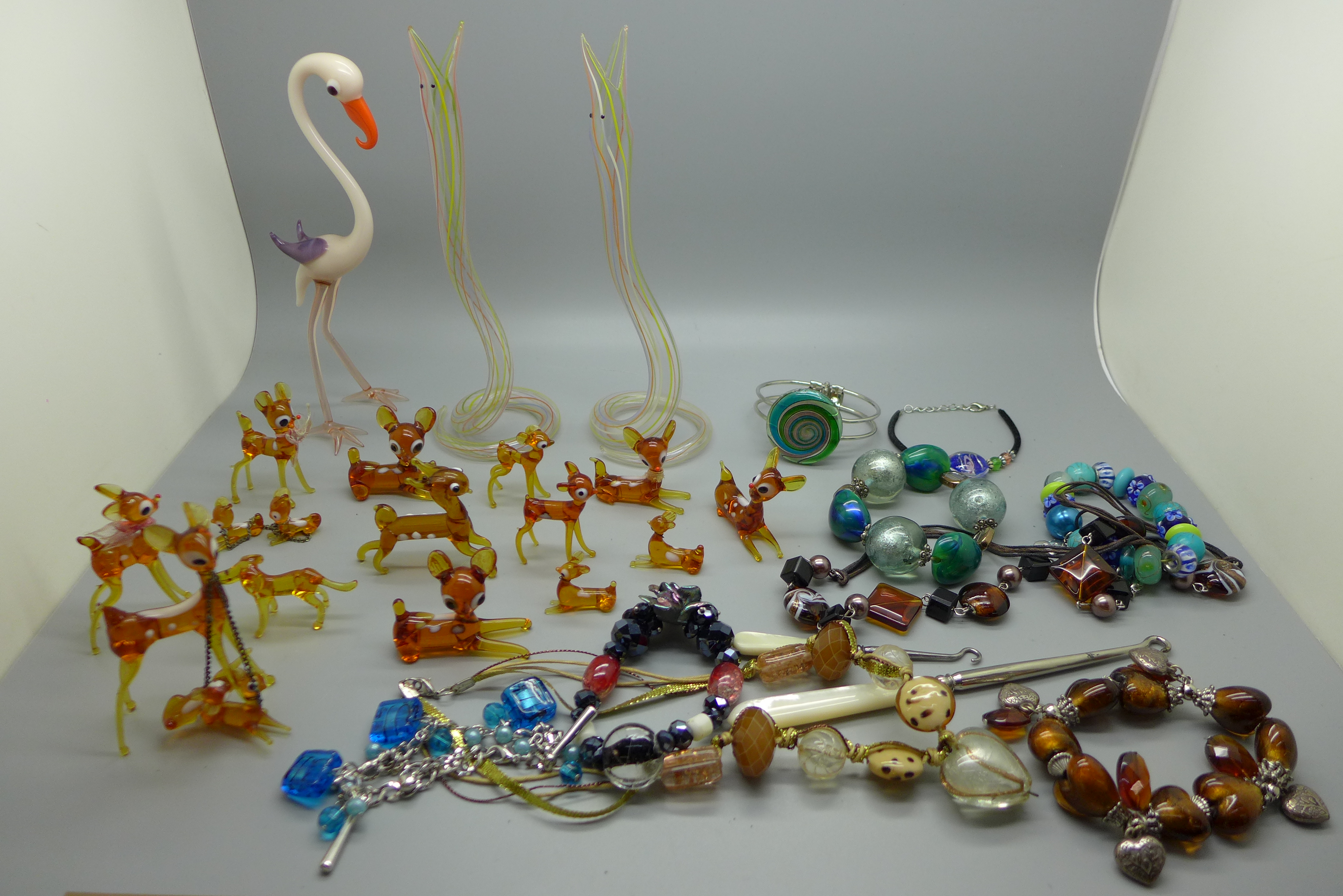 Sixteen deer, one dog, two hollow glass snakes and one flamingo glass animals and various glass bead