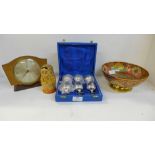 A cloisonne bowl, a set of plated mini goblets, a wooden clock and a Russian doll