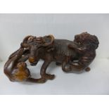 A carved figure group, two lions attacking a buffalo