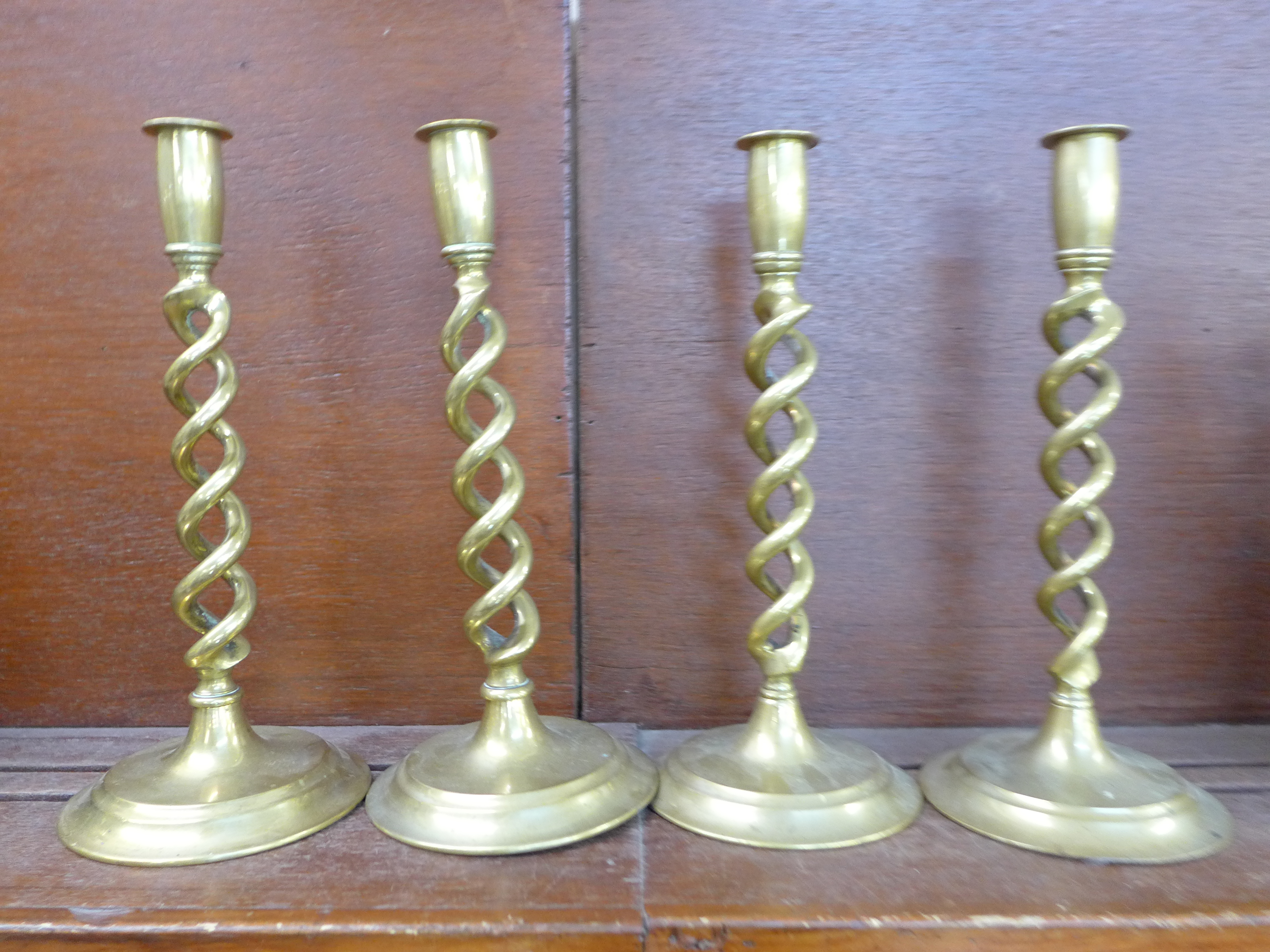 A set of four brass open-twist candlesticks