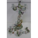 A late 19th/early 20th Century flower encrusted figural three-branch candelabra and one other