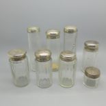 Eight silver topped glass bottles