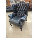 A mahogany and blue leather Chesterfield wingback armchair