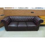A burgundy faux leather Chesterfield settee