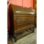 An early 20th Century carved oak cantilever action bureau