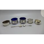 A pair of silver salts, Birmingham 1904, three silver napkin rings and a silver salt spoon, 87g,