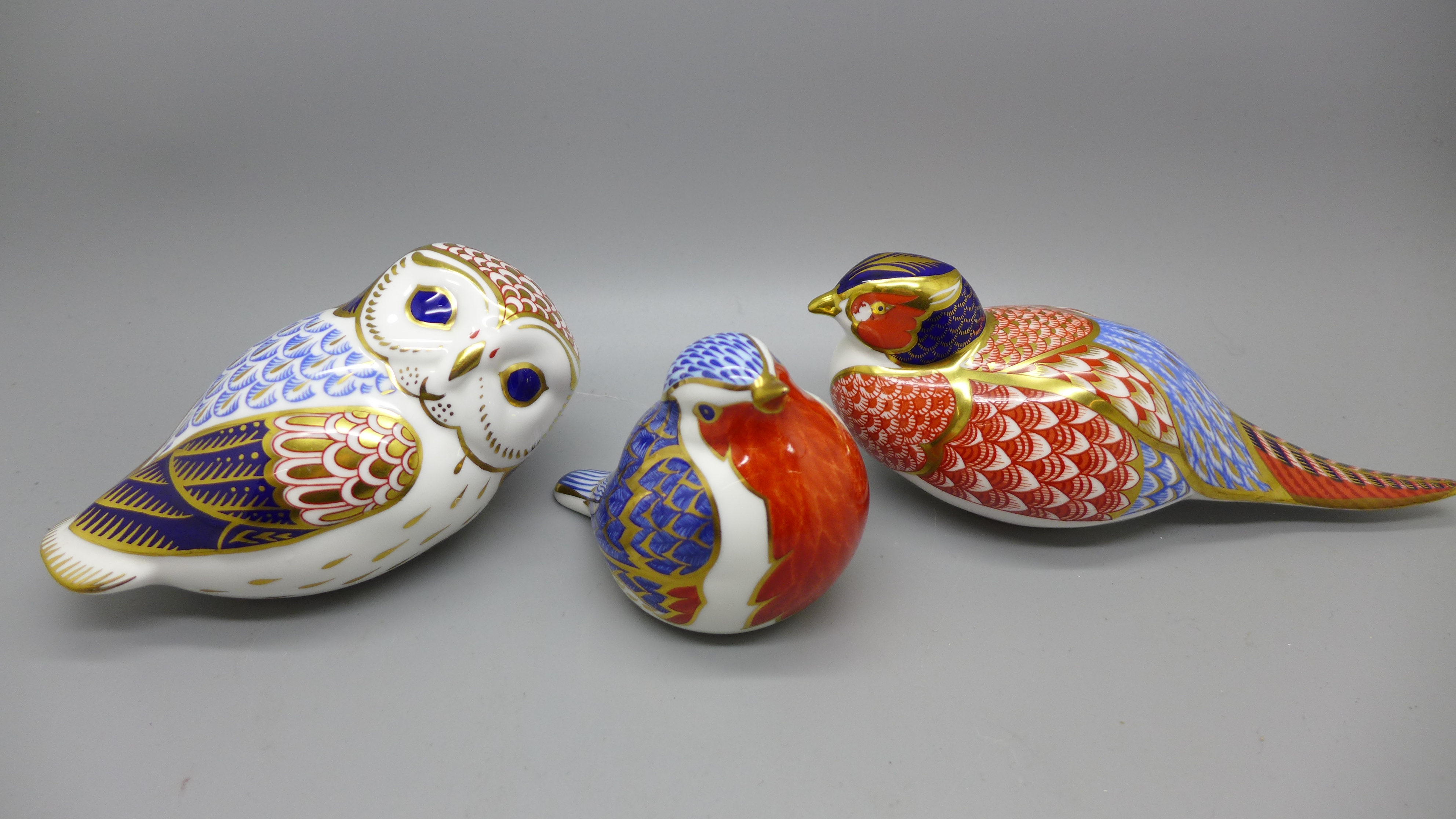 Three Royal Crown Derby paperweights, two birds and an owl, two with silver stoppers