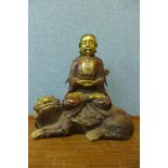 An gilt bronze figure of a sage seated on a dragon, 31cms h