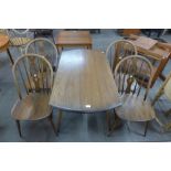 An Ercol Golden Dawn elm and beech Windsor drop leaf table and four chairs