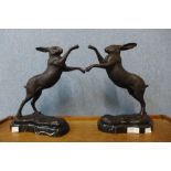 A pair of bronze figures of boxing hares, on black marble socles, 29cms h