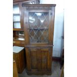 A carved oak freestanding corner cabinet