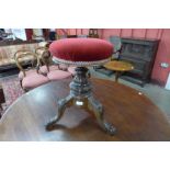 A Victorian walnut revolving piano stool