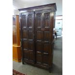 An Elizabethan Revival carved oak two door press cupboard