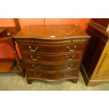 A George III style mahogany serpentine bachelors chest of drawers, with brushing slide