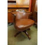 An early 20th Century mahogany and faux leather revolving desk chair