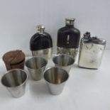 Three hip flasks and a set of four cups