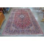 A fine Persian hand knotted red ground Kashan rug, 373 x 249cms