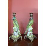 A pair of French style painted porcelain and gilt metal mounted parrot candlesticks