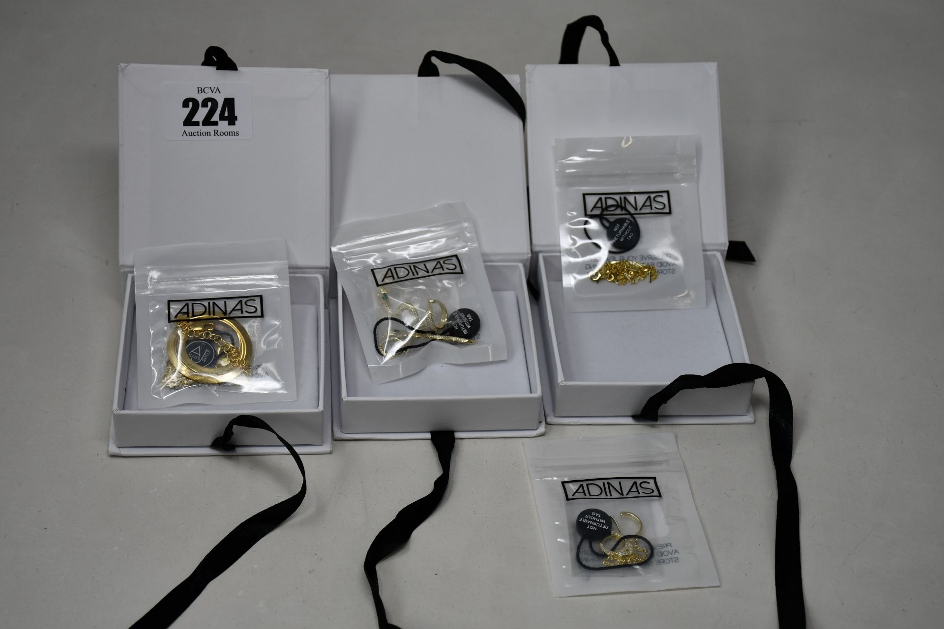 Four items of as new Adina's Jewels jewellery; a Pavé Snake Ear Cuff X Huggie earring combo set (RRP