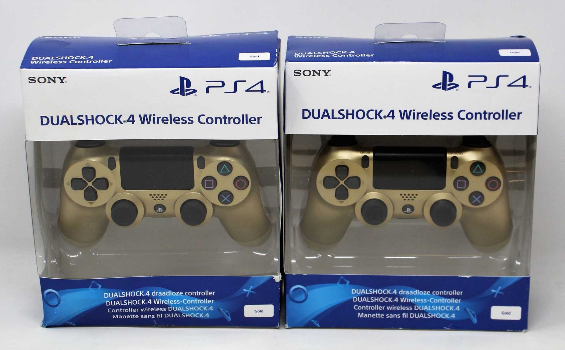 Two boxed as new Sony PlayStation DualShock 4 Wireless Controllers in Gold (Some damage to boxes).