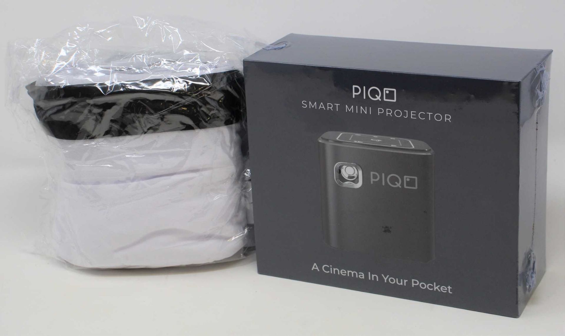 A boxed as new Piqo Smart Android Mini Projector (UK plug adaptor required) (Box sealed) with fabric