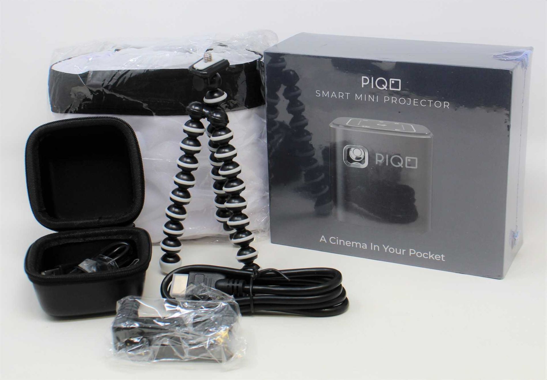 A boxed as new Piqo Smart Android Mini Projector (UK plug adaptor required) (Box sealed) with fabric