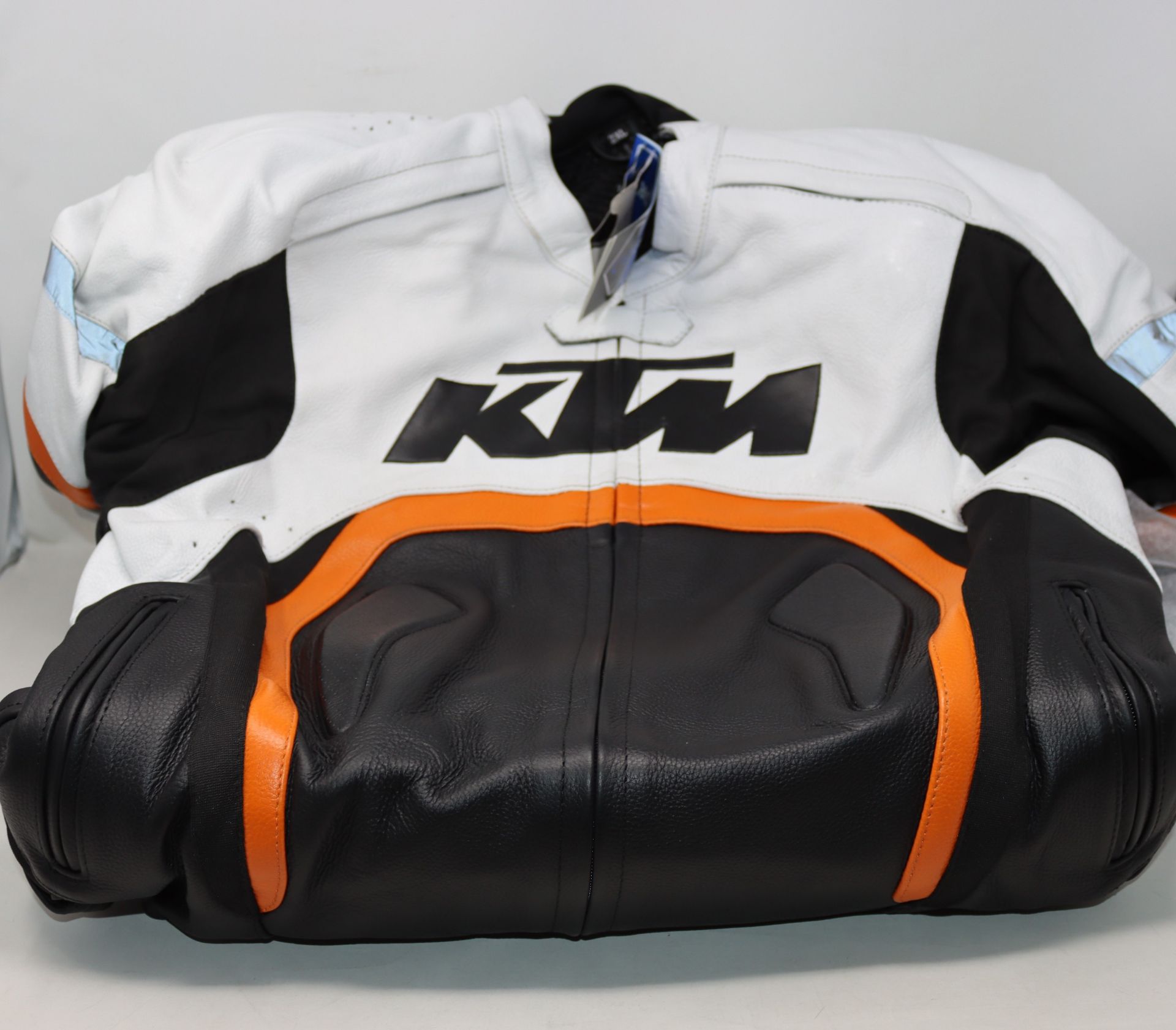 An as new KTM Protector leather motorcycle suit in black and white with orange trim (2XL).
