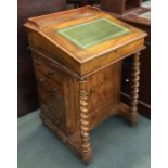 A Victorian walnut davenport, hinged top on barley twist supports, flanked by four drawers and