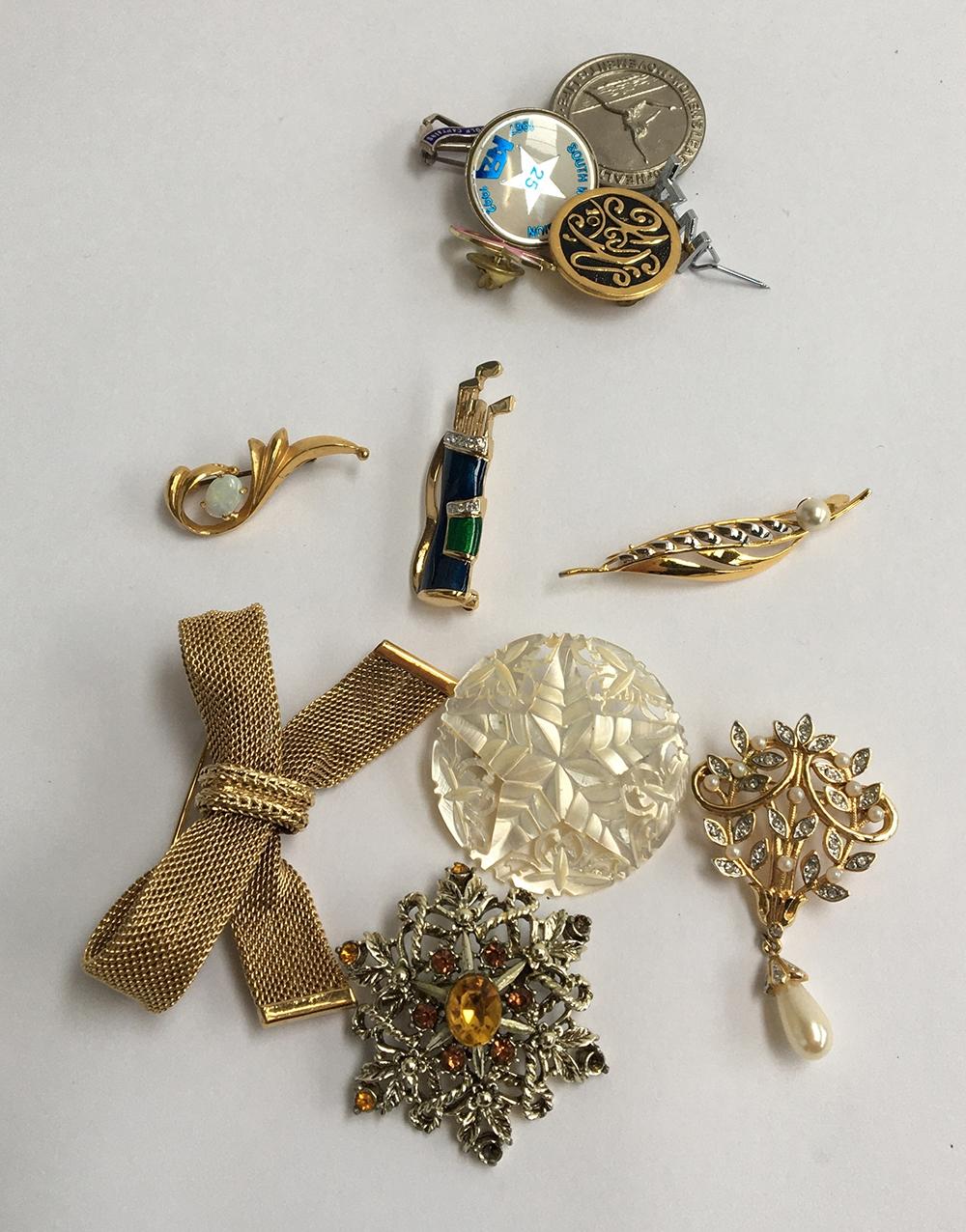 Mixed lot of brooches and badges to include a mother of pearl Bethlehem brooch, a brooch in the form