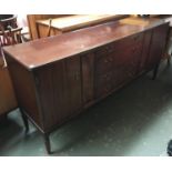 A late 20th century sideboard, comprising four central drawers flanked by two cupboard doors,