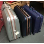 A set of three graduating hard pull-along suitcases; together with two others