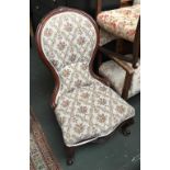 A 19th century nursing chair, floral carved rail, serpentine front on flower capped cabrioles