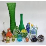 A mixed lot of glass items to include various paperweights, green glass vases, glass flowers, etc