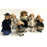 A collection of seven dolls, with stands