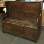 An oak settle with panelled back and front, hinged seat, 121cmW