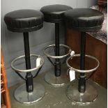 A set of three chrome and black vinyl bar stools,