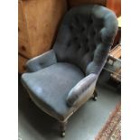 A button back nursing chair on turned legs and casters